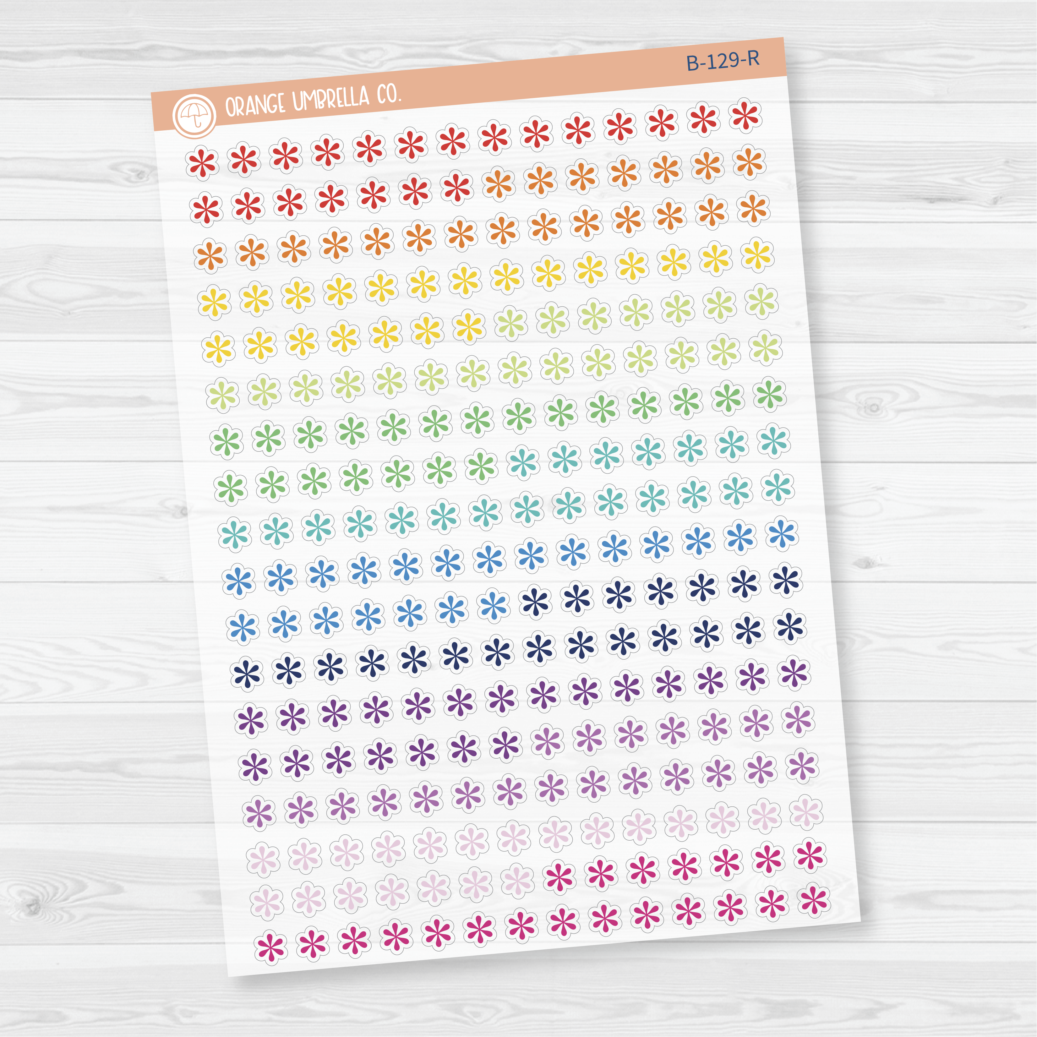 Sheet of asterisk icon planner stickers in rainbow colorways, styled flat lay