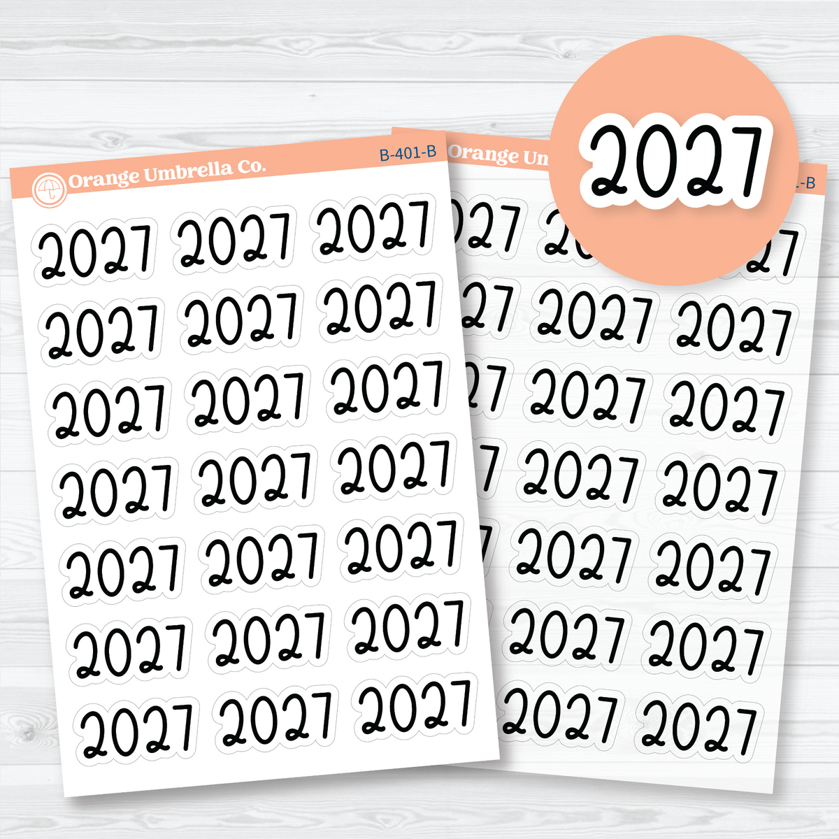 Large black 2027 year label stickers in rounded Font 18 lettering, shown on white matte and clear matte sheets for planner and journal headings.