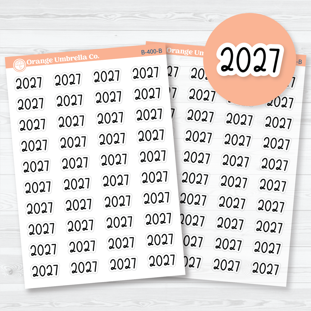 Medium black 2027 year label stickers in rounded Font 18 lettering, shown on white matte and clear matte sheets for planner and journal headings.