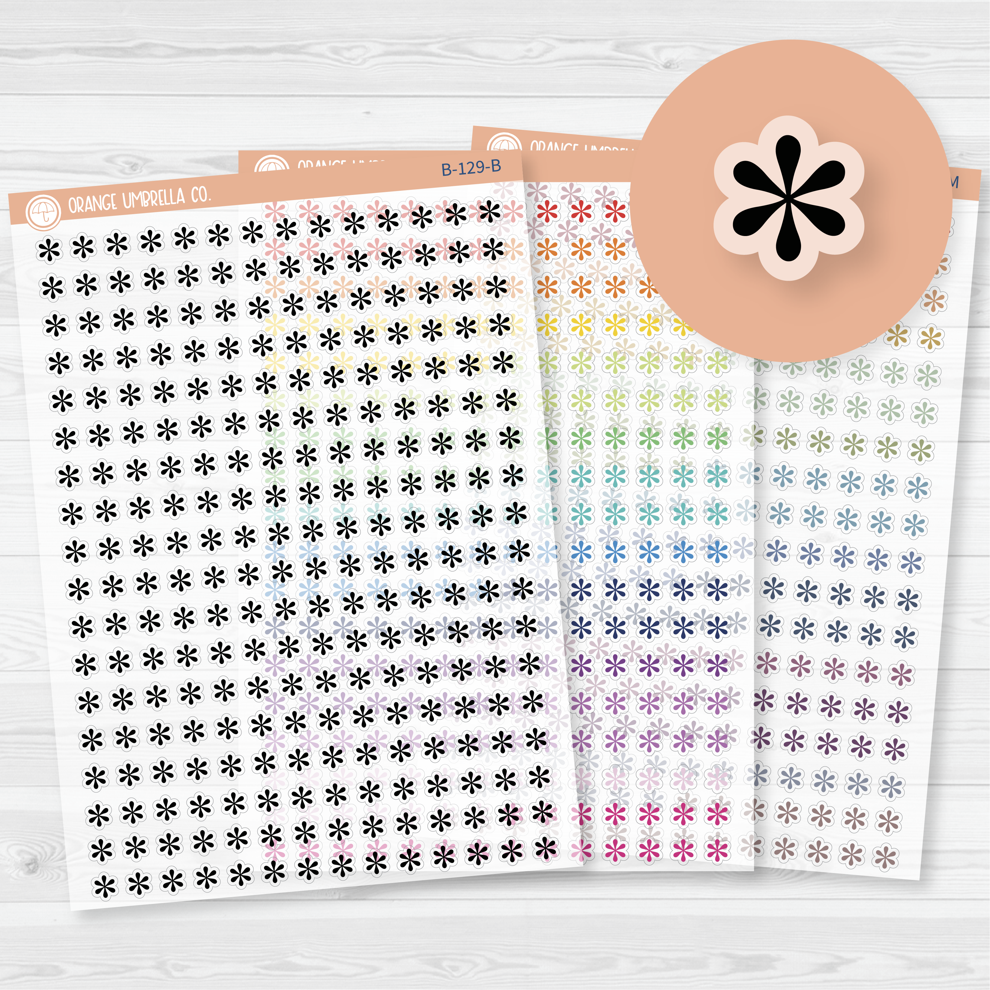 Sheet of asterisk icon planner stickers in rainbow and neutral colorways, styled flat lay