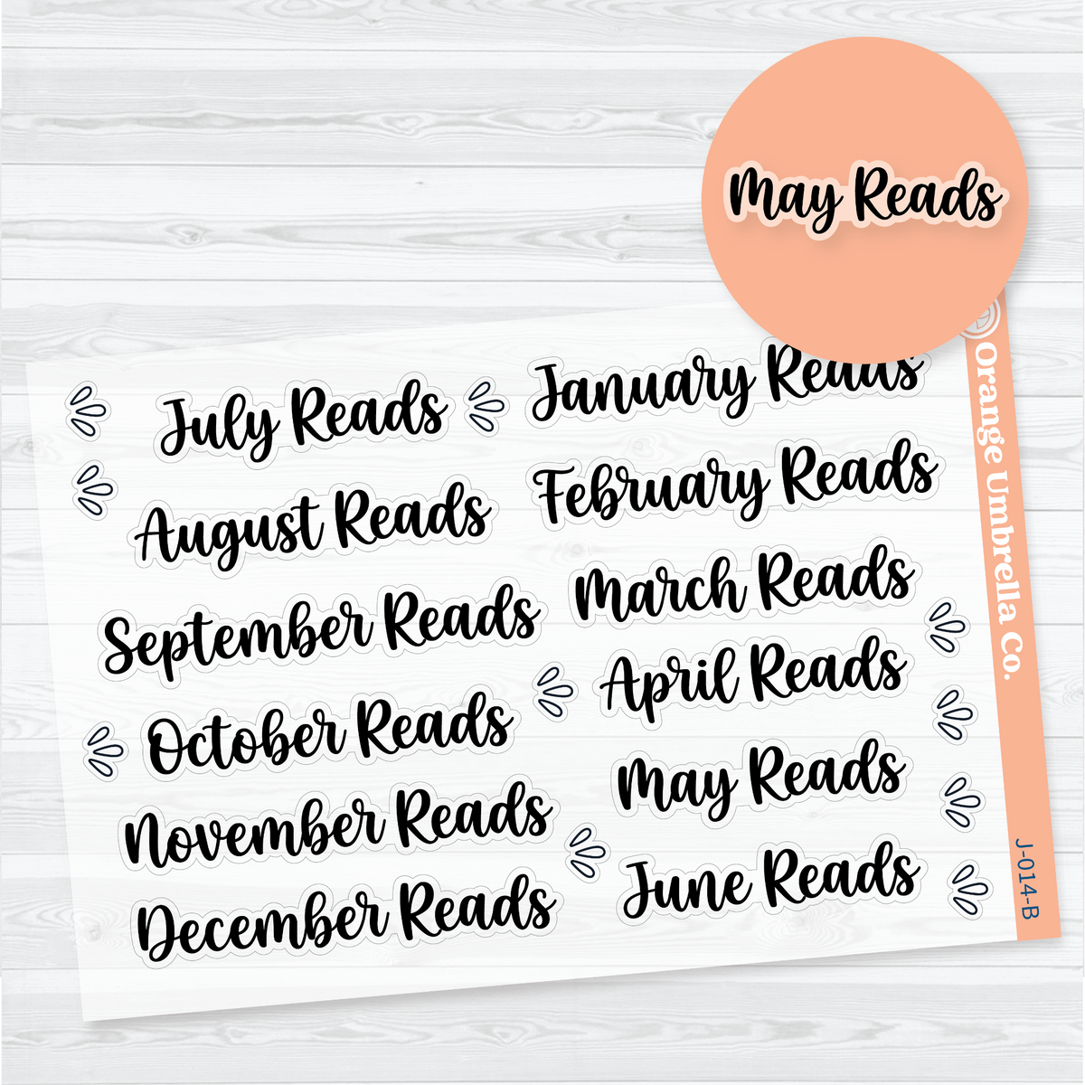 Clear matte sticker sheet with twelve black brush-script Monthly Reads headings from January Reads through December Reads and splash accents for reading journals.